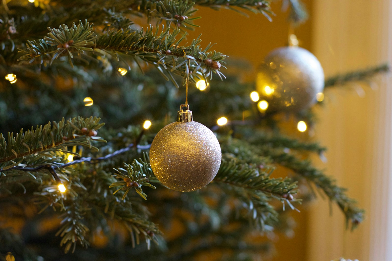 Christmas tree up close with gold Christmas baubles